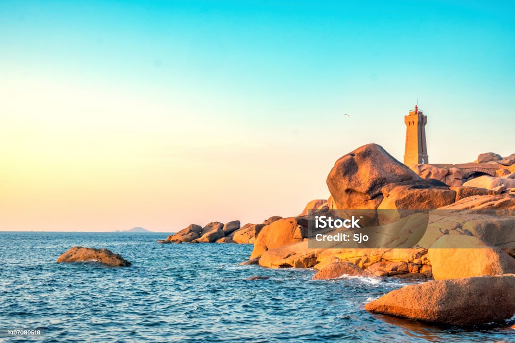 Ploumanach lighthouse at the pink granite coast in Brittany, France during sunset Ploumanach lighthouse or Phare de Men Ruz at the pink granite coast in Brittany, France during a beautiful summer sunset. France Stock Photo