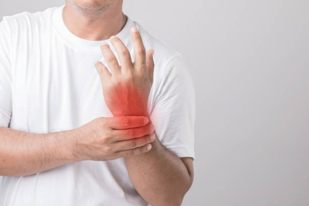 istock Close up man touching his Wrist and feeling a pain. Studio shot isolated on grey background with copy space for text 1407080647