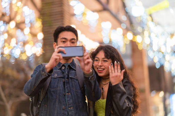 istock Couple taking self-portrait with phone camera in city. 1407081514
