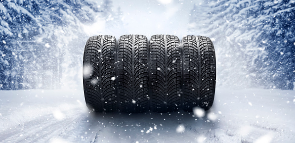 Winter tires on snowy road. Wide car tire banner for bussiness, panorama landscape or ice background.