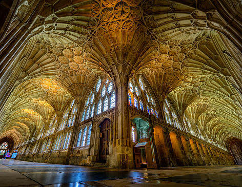 The very elegant Cloisters in Gloucester Cathedral showing its arches and also its very intricate and unique architecture.