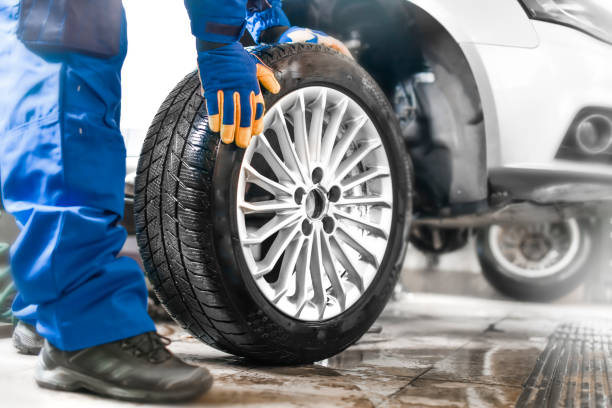 istock Auto mechanic working in garage and changing wheel alloy tire. 1407084480