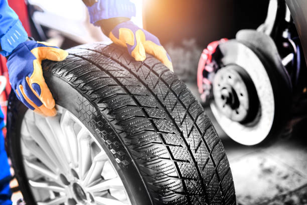 istock Auto mechanic working in garage and changing wheel alloy tire. 1407084481