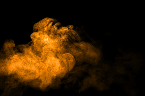 gold dust powder explosion. The texture is abstract and splashes float. on a black background