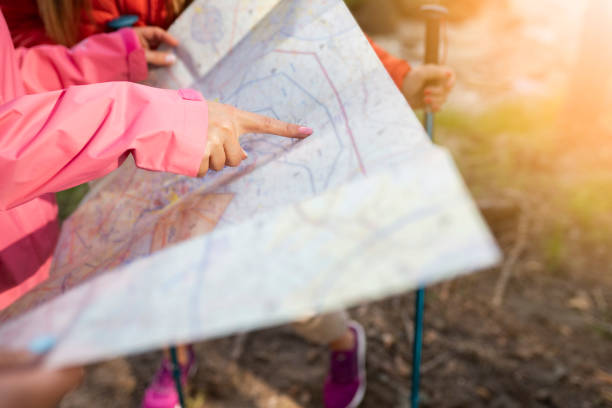 istock trekking woman hand pointing route on map 1407087292