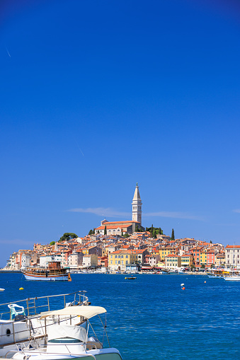 Beautiful view across the blue sea on Rovinj old townscape with bell tower under the clear sky in summer