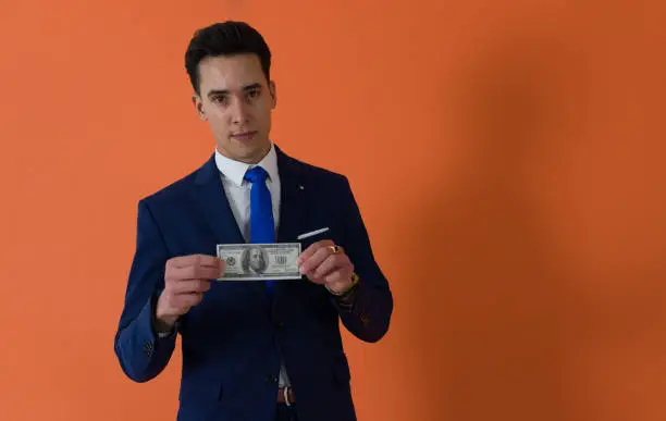 Photo of shaved-face nice-looking man holding one US dollar bill with neutral expression