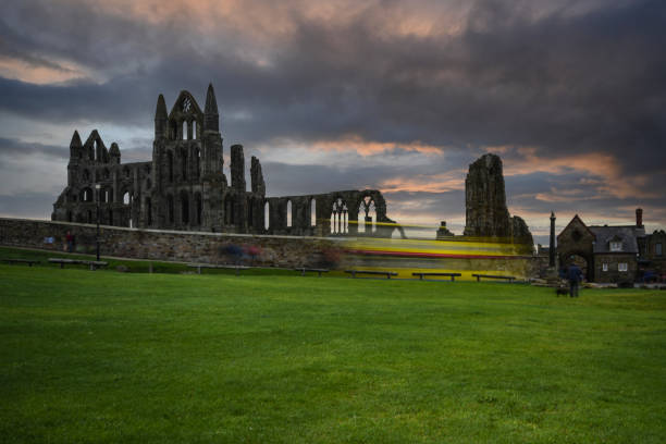 A bus passes by Whitby Abbey on a wet  and dull day.