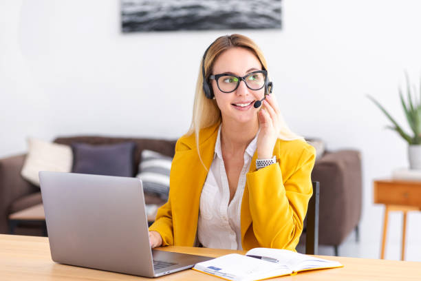 istock Woman customer support call center operator or receptionist in headset consulting client using video call. Portrait of a young female administrator in a headphones working at a workplace 1407093084