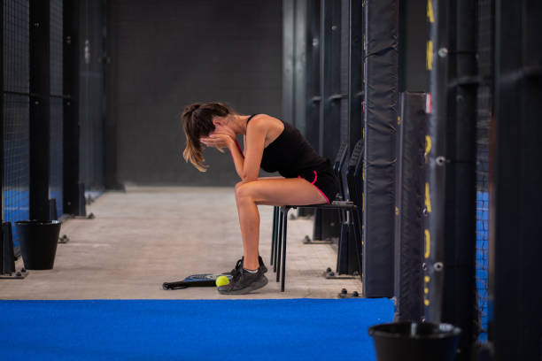 portrait of young woman lost the padel or tennis match - portrait of paddle tennis player crying for the loss of match - tennis indoors court ball imagens e fotografias de stock