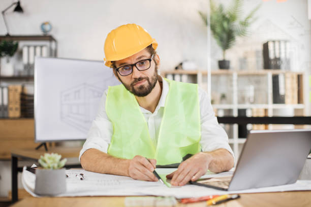 istock Architect man or male builder hold pen and ruler, writing and drawing architectural project. 1407093304