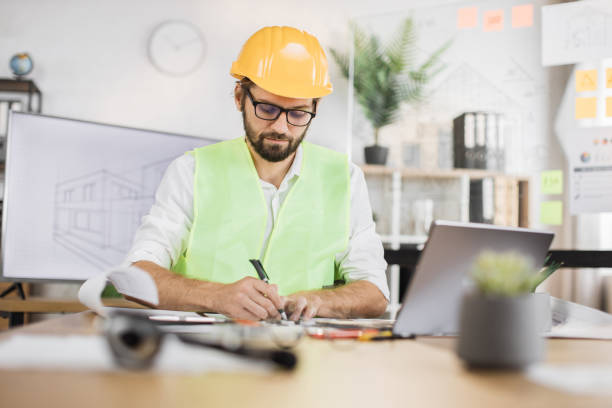 istock Architect man or male builder hold pen and ruler, writing and drawing architectural project. 1407093307
