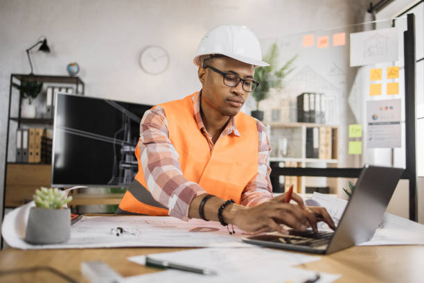 istock Focused african american man worker creating new building project sitting in modern office. 1407093336