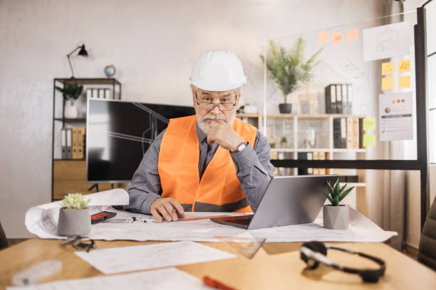 istock Competent mature engineer, designer or architect leading working conference at office center 1407093406