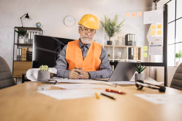 istock Competent mature engineer, designer or architect leading working conference at office center 1407093410