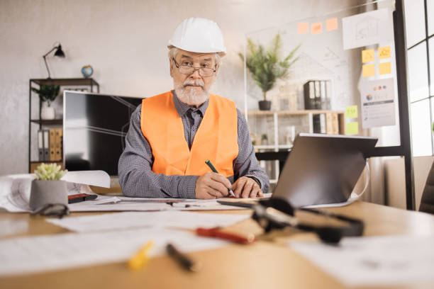 istock Focused caucasian mature man worker creating new building project sitting in modern office. 1407093414