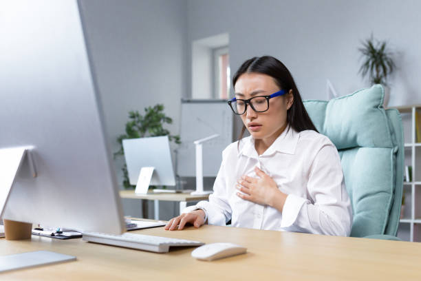 istock Young beautiful asian female office worker tired and sick having severe chest pain and breathing problems panic attack business woman 1407093708
