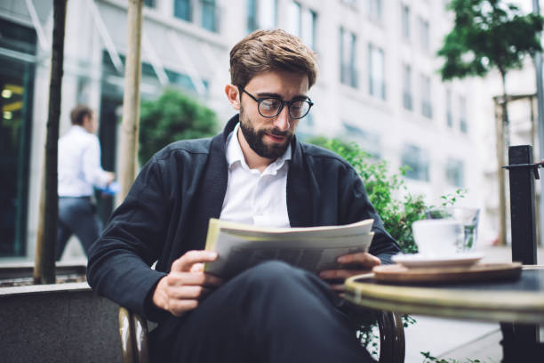 istock Man enjoying reading newspaper in cafe 1407093769