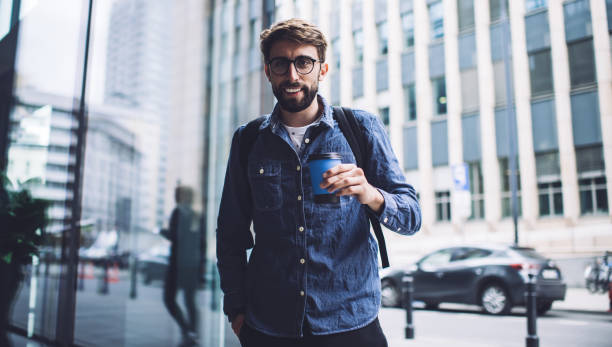 istock Positive man standing on street and looking at camera 1407093786