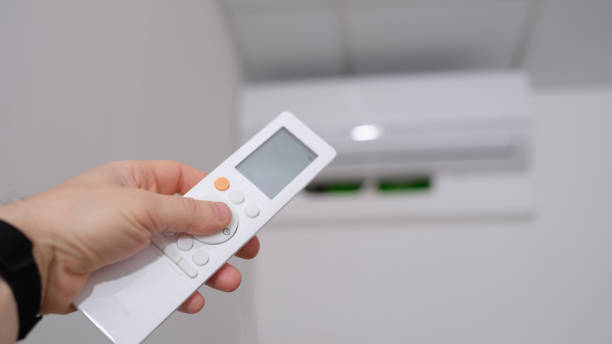 istock Person manual air conditioner with remote control closeup 1407096531