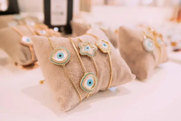 Photo of Jewelry precious bracelets on display on a pillow with a Turkish amulet against the evil eye