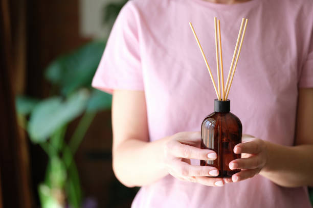 Person holds bottle of incense and aromatherapy incense sticks stock photo