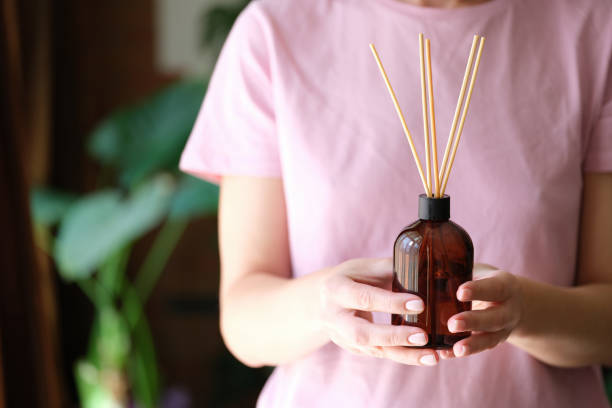 Person holds bottle of incense and aromatherapy incense sticks Person holds bottle of incense and aromatherapy incense sticks. Essential oils concept home diffuser stock pictures, royalty-free photos & images