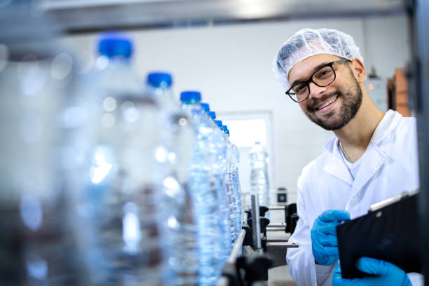 istock Worker checking bottles at water factory. 1407097524