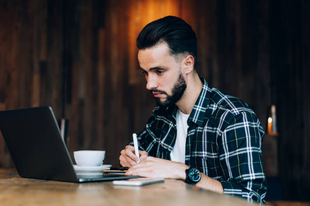 istock Focused young businessman in loft cafe during remote work 1407097697