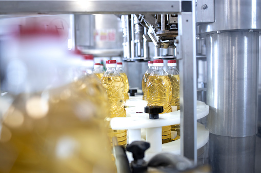 Sunflower vegetable oil in bottles being produced in food factory.