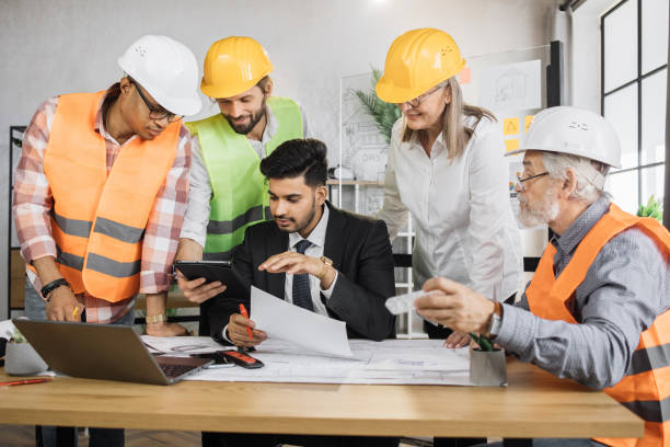 istock Multicultural partners working with drawings inspection during conference at modern office. 1407098621