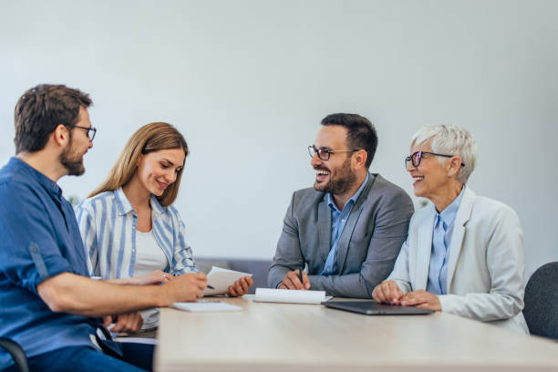 istock Four people at the office, signing some contracts, making plans together. 1407098879