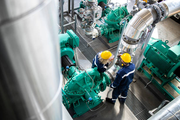 istock Industrial workers or serviceman standing on refinery platform checking gas pipes and engine generators. 1407098906
