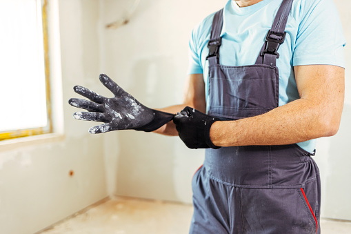 Worker putting on work gloves