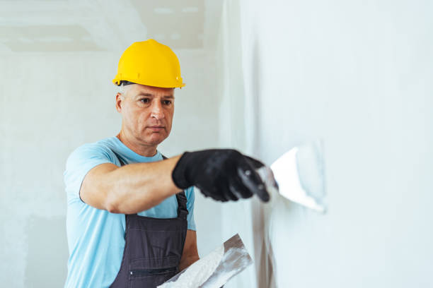 appaltatore in hardhat bianco intonacatura di una parete - plaster plasterer wall repairing foto e immagini stock