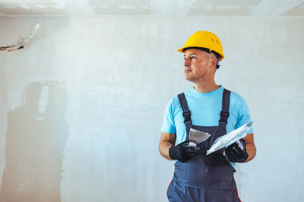 istock Smiling Mature Man Plastering Wall in his Workshop 1407100563