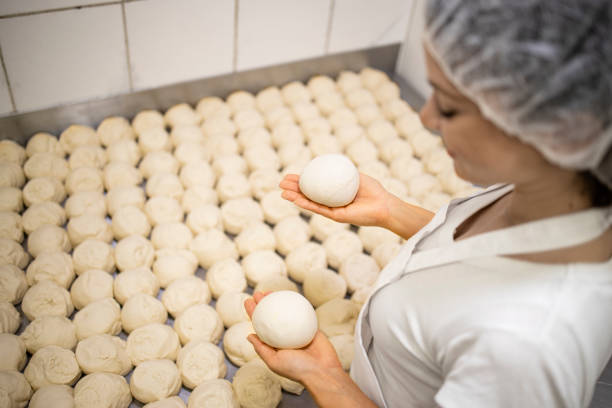 istock Close up view of baker hands kneading and preparing dough or bred for baking. 1407100865