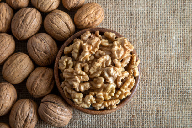 istock Peeled walnuts and whole walnuts on fabric background 1407102456