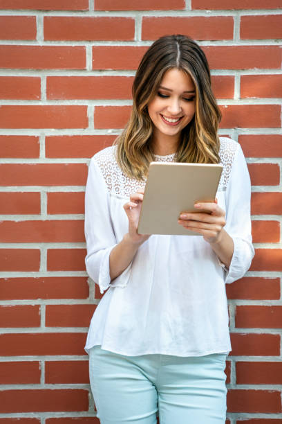 youth and technology. attractive young business woman using tablet computer outdoors. - surfing wireless vertical outdoors lifestyles imagens e fotografias de stock