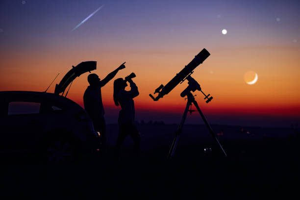 istock Couple stargazing together with a astronomical telescope. 1407102968