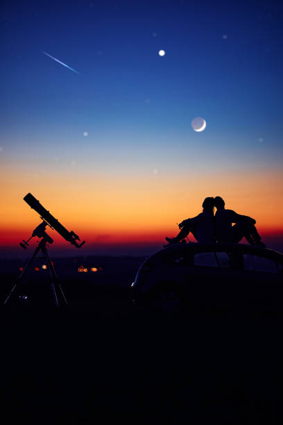 istock Couple stargazing together with a astronomical telescope. 1407103036