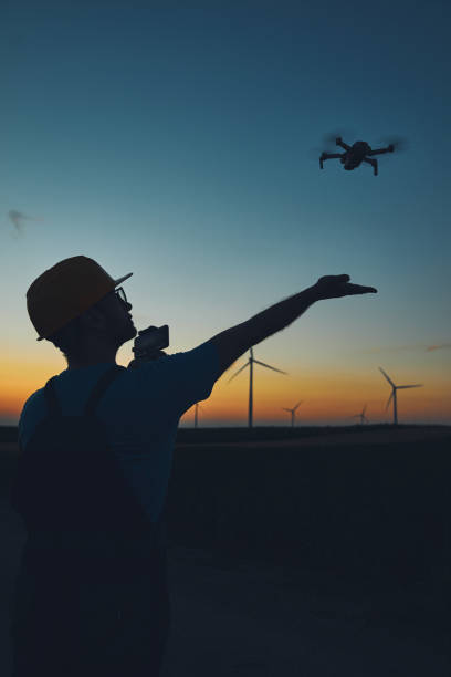 istock Engineer mechanic using drone for inspection in a windmill farm park. 1407103096