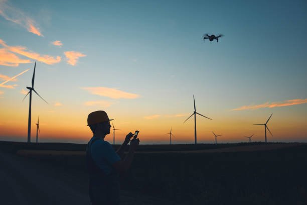 istock Engineer mechanic using drone for inspection in a windmill farm park. 1407103126