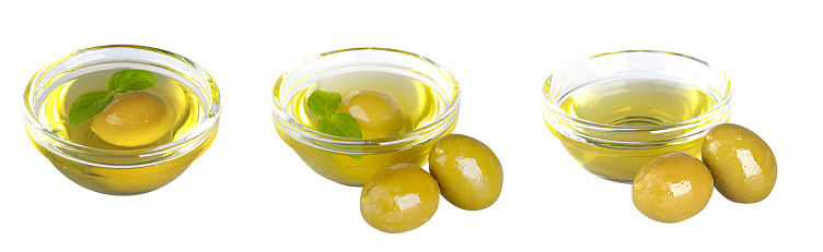 Glass bowl with olive oil and olives isolated on a white background