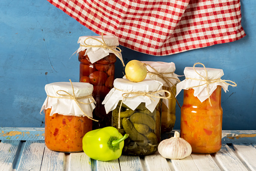 Marinated Cucumbers Tomatoes Squash Lecho in Jars are Located on Wooden Background Harvest for the Winter Horizontal Napkin