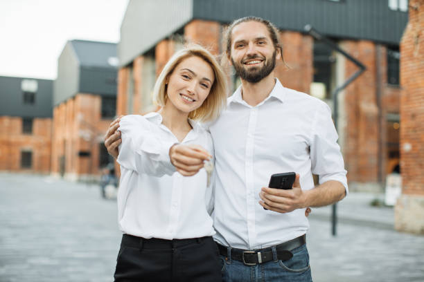 istock Happy smiling couple showing keys, smiling at camera, 1407112962
