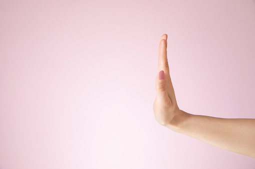 Stop hands sign, studio shot on pink background