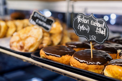 View of chocolate and Boston filled yellow custard donuts and croissants at Pennsylvania food market.