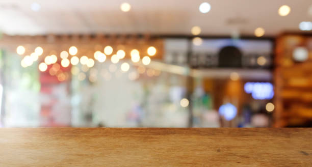 istock Wood  top table Blur coffee shop or cafe restaurant with abstract bokeh light image background. People in store Blur Background or design key visual layout 1407116439
