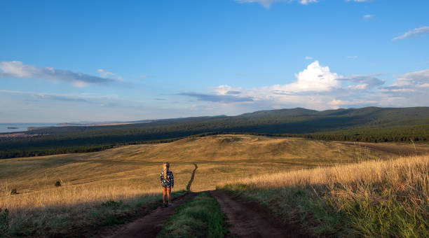 Lone girl is looking to the horizon of the scenic view of the island. Lone girl is looking to the horizon of the scenic view of the Olkhon island. siberia summer stock pictures, royalty-free photos & images